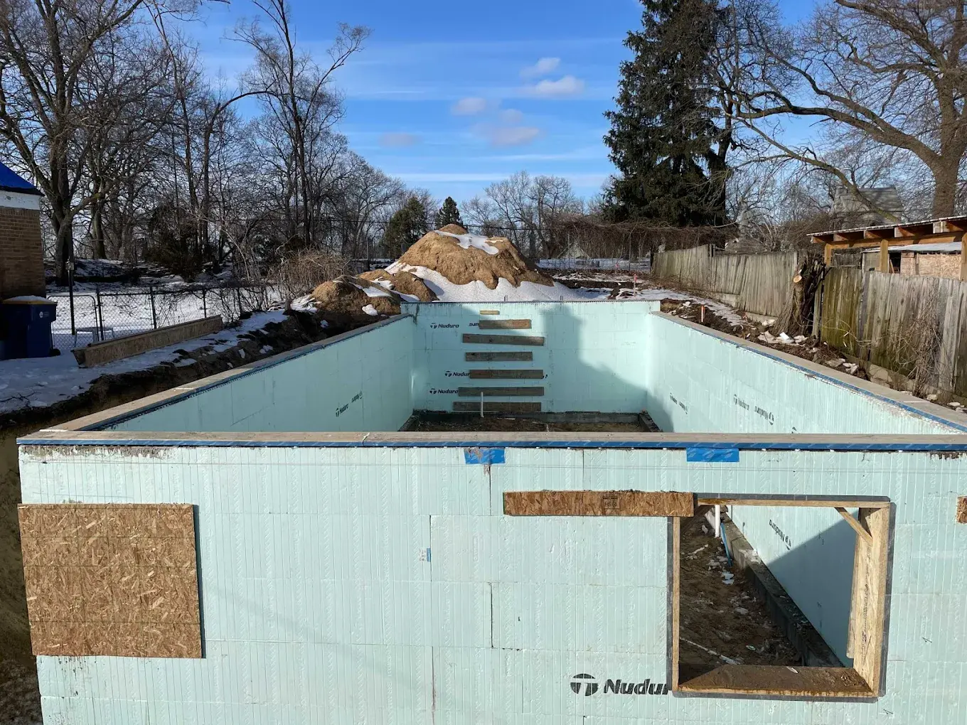 ICF insulated concrete form foundation for a detached ADU with window cutouts and stepped footing