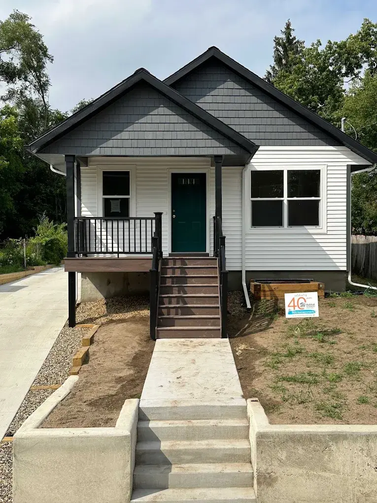 Completed detached ADU with dark trim, teal front door, and covered porch entry in the Greater Seattle area